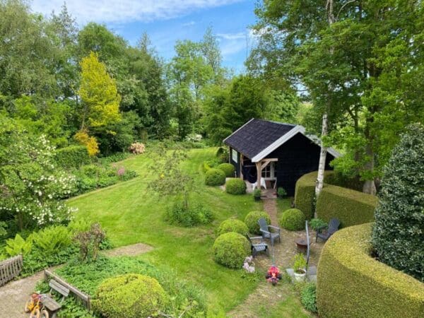 Sfeervolle tuin en imkerij tussen de weilanden. Tijnje