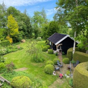 Sfeervolle tuin en imkerij tussen de weilanden. Tijnje